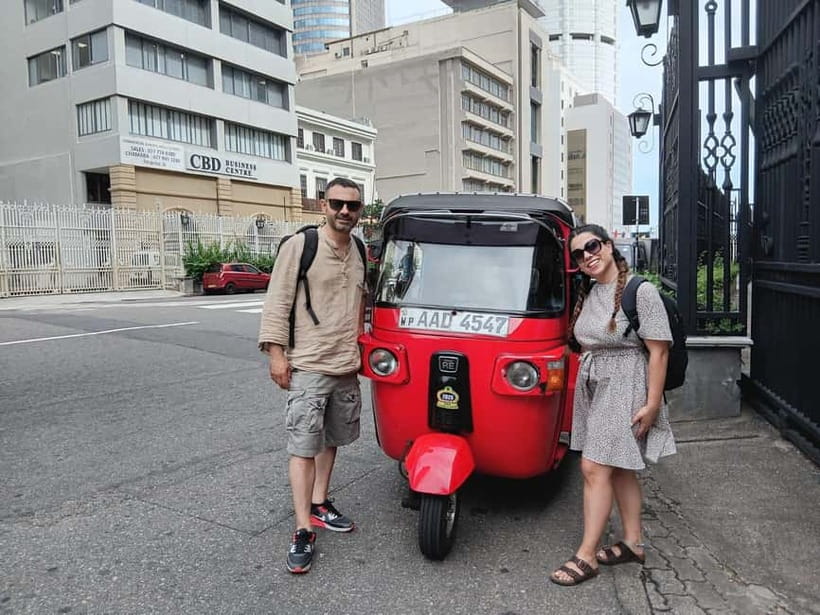 A red tuk-tuk waiting on a Colombo side street